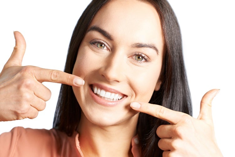 Woman Pointing To Her Smile With Perfect White Teeth