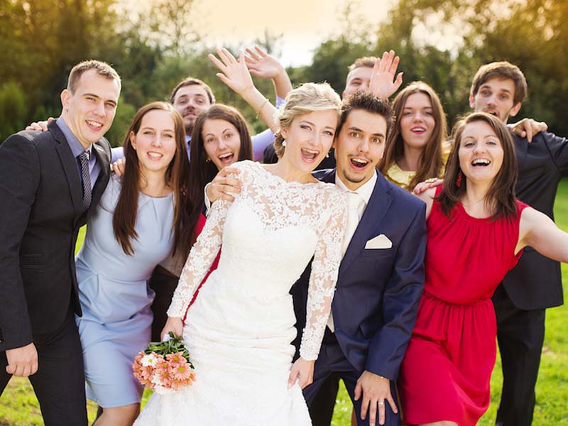 a group of people posing for photo in a wedding