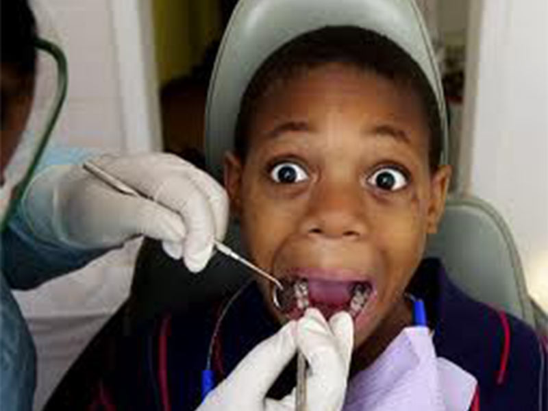young boy looking shocked while having teeth examined