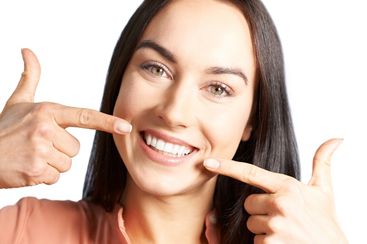 Woman Pointing To Her Smile With Perfect White Teeth